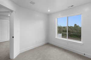 Carpeted empty room featuring baseboards and recessed lighting