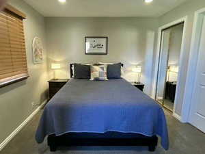 Carpeted bedroom featuring recessed lighting and a closet