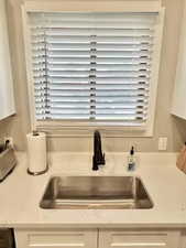 Kitchen view of white cabinets and light stone countertops