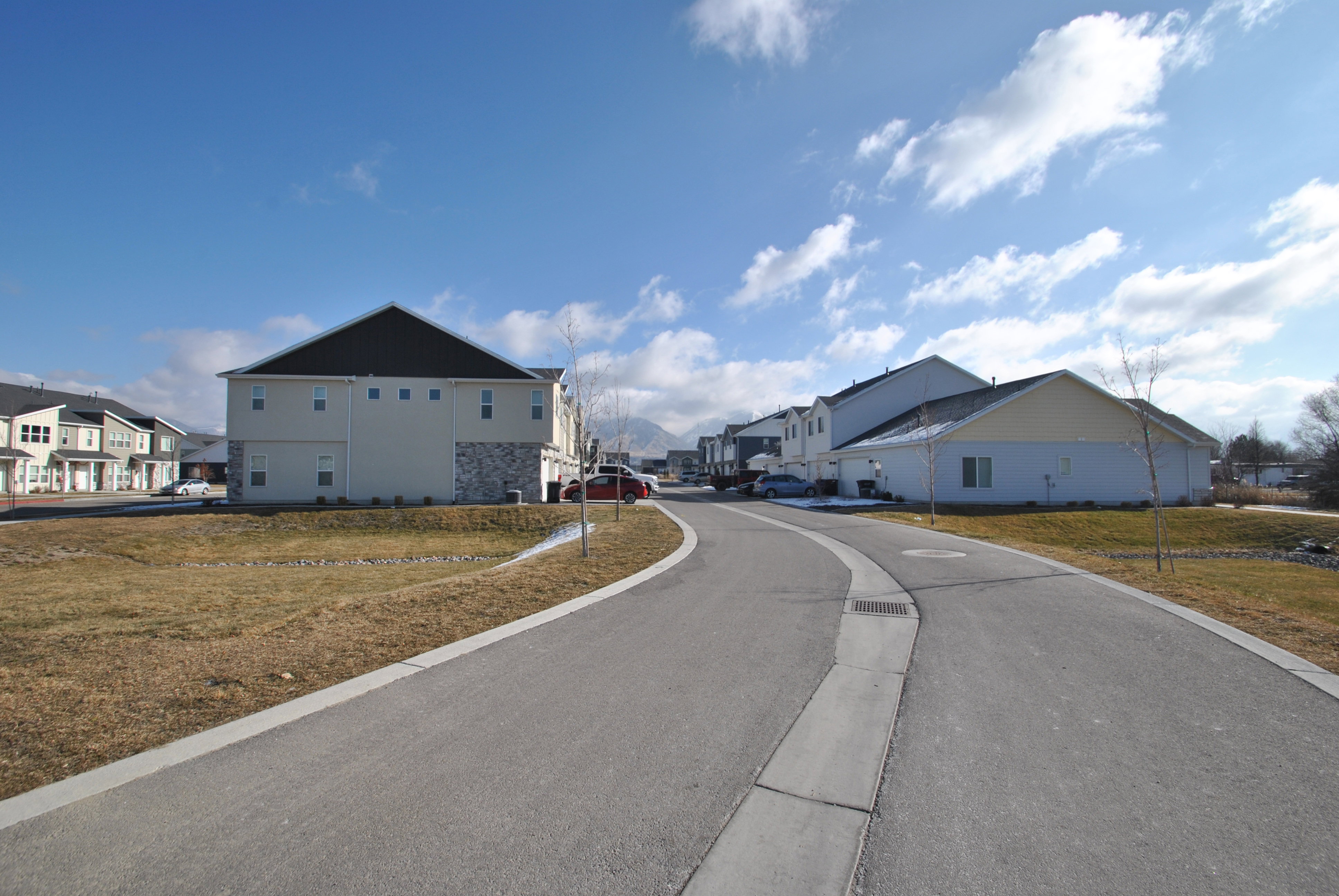View of asphalt street with access to the garages.