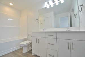 Primary Bedroom attached Bathroom with double vanity, light wood-style floors, shower / bathtub combination, and recessed lighting