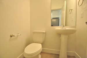 Half bathroom featuring baseboards and wood finished floors