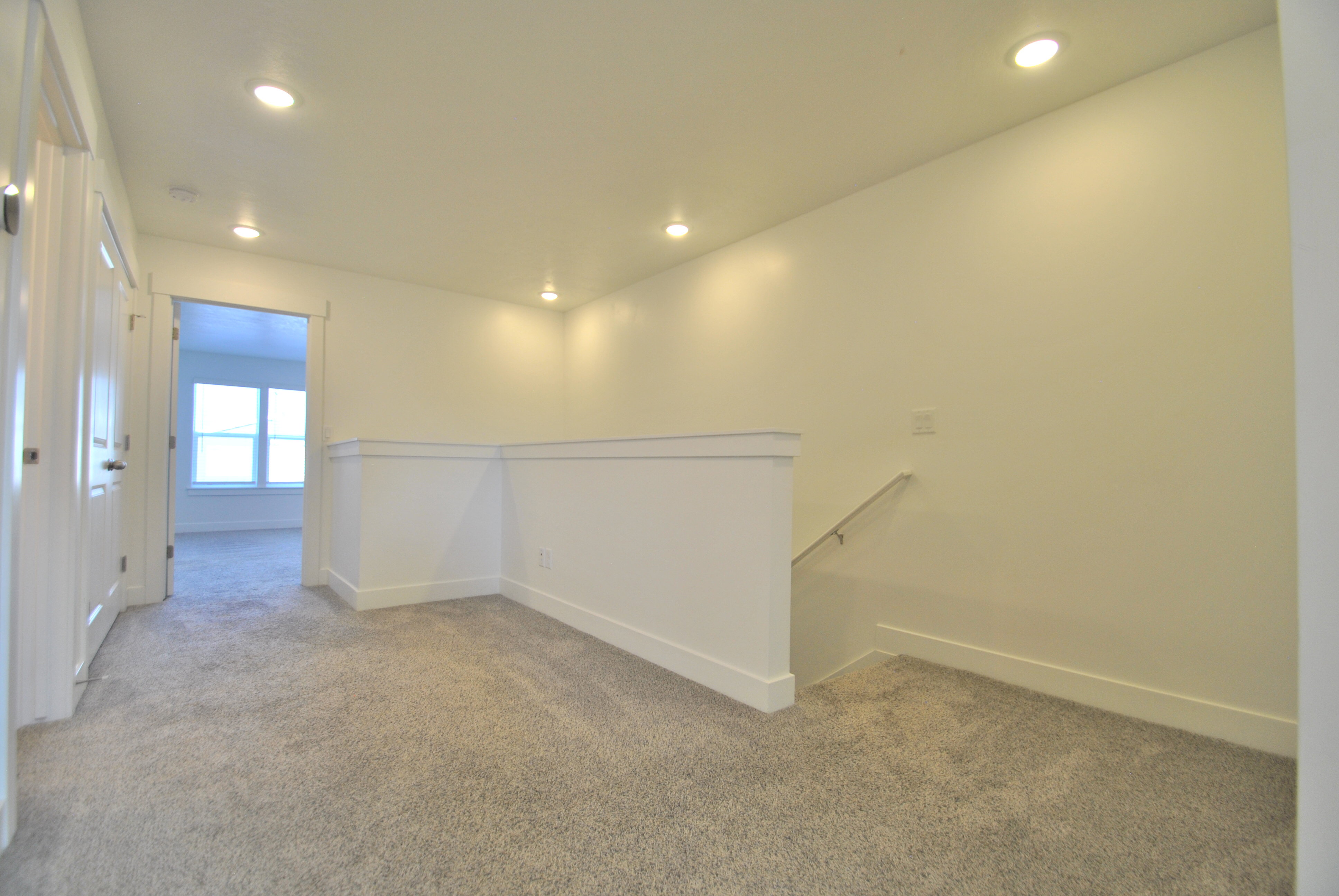 Carpeted loft space featuring recessed lighting, carpeted floors, and access to the bedrooms, laundry, and guest bathroom