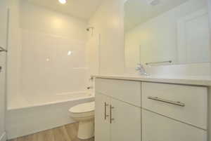 Full bath with vanity, bathtub / shower combination, light wood-type flooring, and recessed lighting