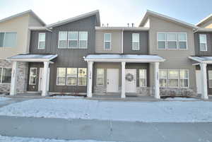 View of front of house featuring stone siding, a porch, and board and batten siding