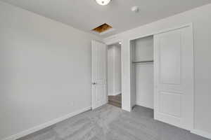 Unfurnished bedroom with light carpet and a closet