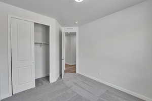 Unfurnished bedroom featuring light carpet and a closet