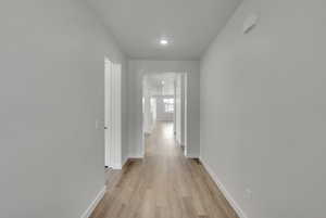 Hall featuring light wood-style flooring and recessed lighting
