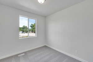 Carpeted empty room featuring baseboards
