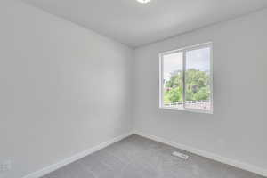 Carpeted spare room with baseboards