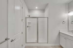Full bath featuring vanity, a stall shower, and light tile patterned floors