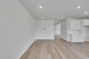 Unfurnished living room featuring light wood-type flooring and recessed lighting