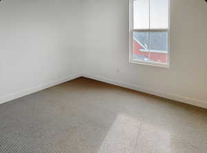 Empty room with carpet flooring and baseboards