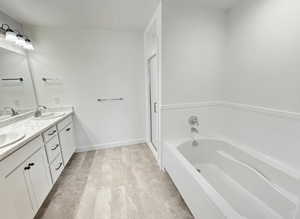 Bathroom featuring double vanity, a garden tub, and a shower stall