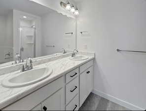 Bathroom featuring double vanity and a shower stall