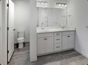 Full bathroom featuring double vanity and toilet