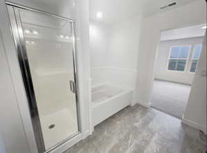 Full bath featuring a garden tub, a shower stall, and light carpet