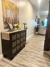 Hall featuring light wood-style flooring and baseboards