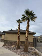 View of side of home featuring stone siding, stucco siding, and a tiled roof