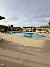 Community pool with a patio area and a residential view