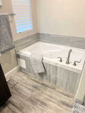 Bathroom featuring a whirlpool tub and baseboards