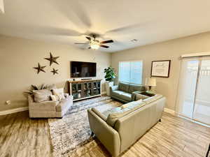 Living area with light wood-type flooring and ceiling fan