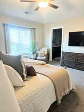 Carpeted bedroom featuring a ceiling fan