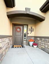 Entrance to property featuring stone siding and stucco siding
