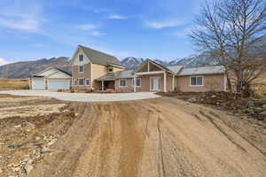 View of front of house with circle driveway, a mountain view and covered porch