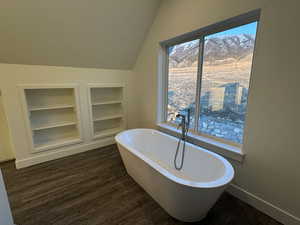 Bathroom with built in shelves, and freestanding tub.