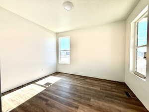 Empty room with wood-type flooring and a textured ceiling