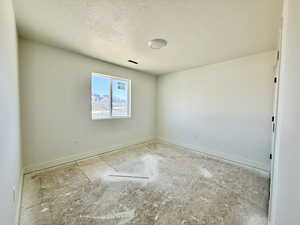 Spare room featuring baseboards and a textured ceiling