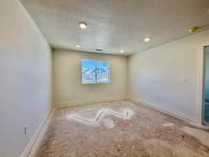 Empty room with baseboards and a textured ceiling