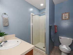 Full bath with vanity, a shower stall, and light tile patterned floors