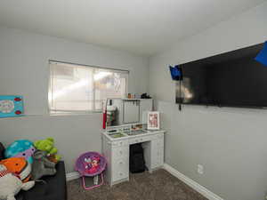 Recreation room featuring dark carpet and baseboards
