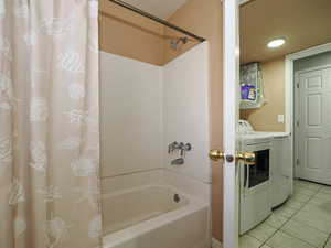 Bathroom featuring shower / tub combo with curtain, washing machine and dryer, tile patterned floors, and recessed lighting