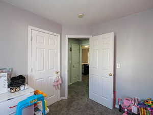 Game room with dark colored carpet and baseboards