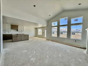 Unfurnished living room with a baseboard heating unit and a high ceiling