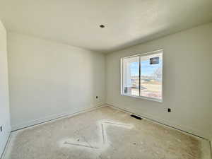 Spare room with baseboards and a textured ceiling