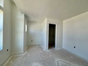 Unfurnished bedroom with a spacious closet and a textured ceiling