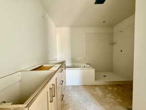 Bathroom with vanity, walk in shower, and a garden tub