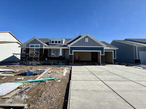 View of front of home featuring a shingled roof, a garage, driveway, and a porch