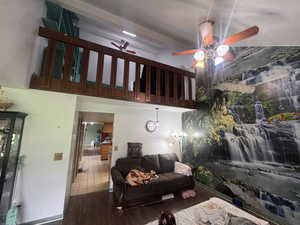 Living room with ceiling fan and dark wood-style flooring