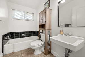 Bathroom featuring vaulted ceiling and a bath