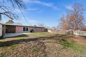 Rear view of property with a fenced backyard, brick siding, and a patio area