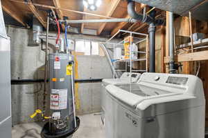 Laundry room with concrete floors, NEW gas water heater, and washing machine and clothes dryer