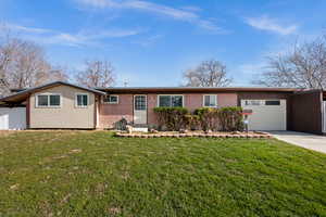 Ranch-style home with an attached garage, driveway, and brick siding