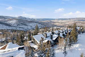 Snowy aerial view with a mountain view and a residential view