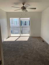 Empty room with ceiling fan, carpet, and a textured ceiling