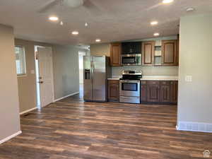 Kitchen featuring appliances with stainless steel finishes, dark wood-style floors, recessed lighting, a textured ceiling, and a ceiling fan